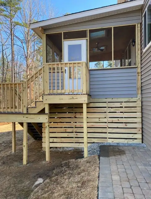 Small wood deck and stairs leading from a screened porch, with a paver landing below