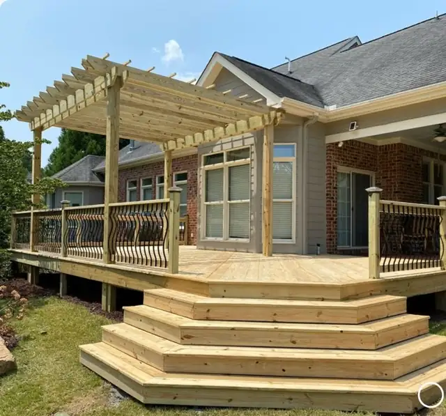 Wood deck with a pergola over the seating area and wide stairs down to the lawn