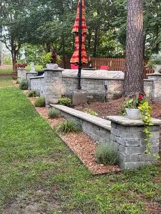Terraced garden beds with stone steps, mulch, ornamental grasses and flowering shrubs